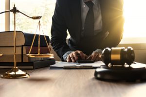 Male,Lawyer,Working,With,Calculator,And,Wooden,Gavel,On,Tabel